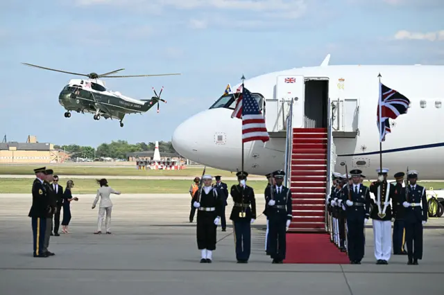 A US military helicopter lands beside the royal flight