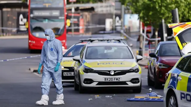 Forensic police officers inspect the scene where two Jewish men were stabbed in Golders Green, north London.