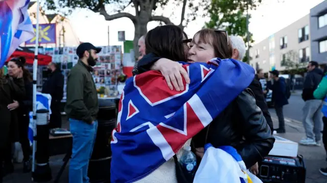 People hug each other during a protest near the scene in Golders Green, north-west London