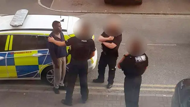 Calocane being spoken to by police after breaking into a flat in May 2020
