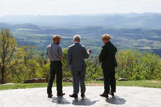 King stands with park officials and looks out over a green landscape