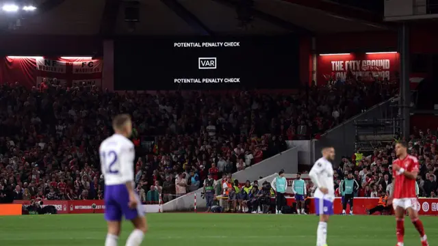 The LED screen displays that a VAR check is underway for a potential penalty for a handball by Lucas Digne