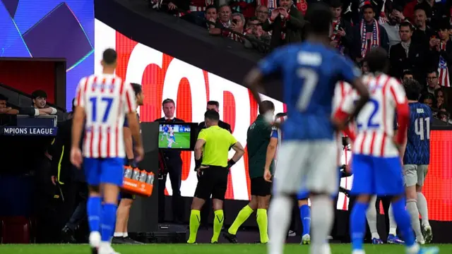 Referee checks the VAR monitor for a penalty
