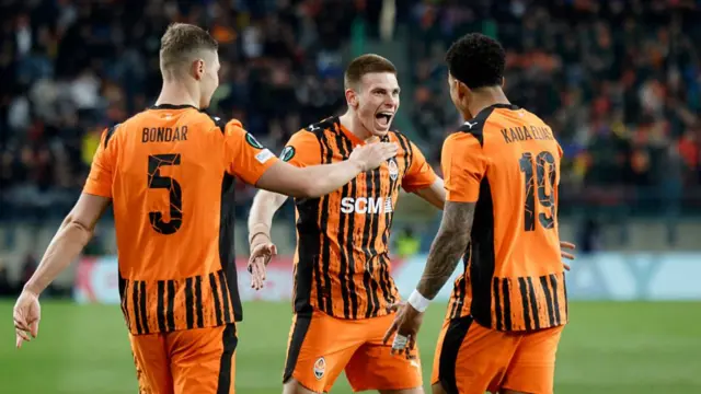 7 Oleg Ocheretko (C) celebrates scoring his team's first goal with Shakhtar Donetsk's Brazilian forward #19 Kaua Elias (R) and Shakhtar Donetsk's Ukrainian defender #05 Valeriy Bondar