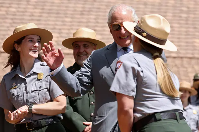 King smiles and gestures as he speaks with parks employees
