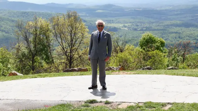 King poses for a photo in front of a scenic backdrop