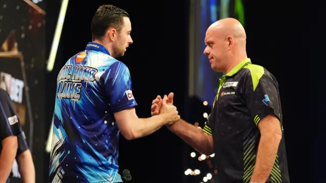 Luke Humphries (left) shakes hands with Michael van Gerwen after victory in their match on night thirteen of the BetMGM Premier League 2026 at P&J Live, Aberdeen