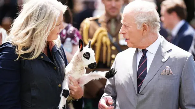 King Charles talks with the keeper holding a Welsh-origin Kerry Hill lamb