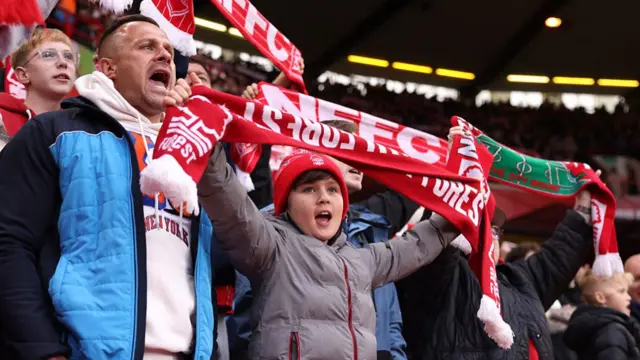 young Nottingham Forest fan holds a scarf