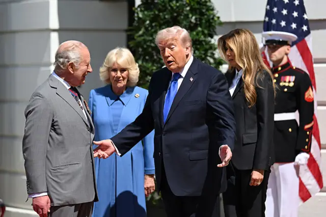 President Trump gesticulates while the King, Queen and first lady look on