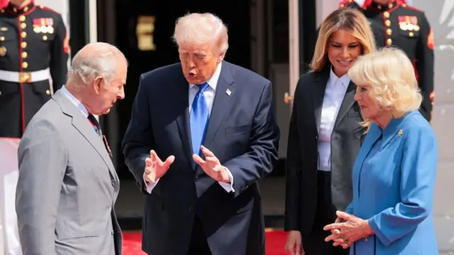 Trump gestures with his hands as he speaks and Charles listens outside the White House