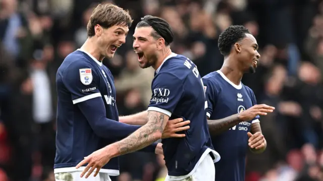 Caleb Taylor (left) puts his arms on Tristan Crama's waist as the pair exclaim in joy with their mouths open