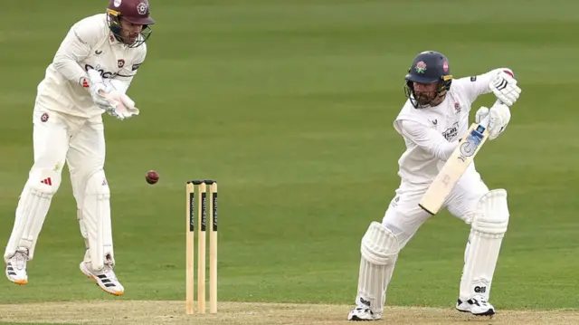Josh Bohannon cuts past Northants wicketkeeper Lewis McManus