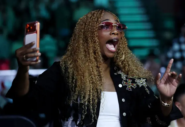 Claressa Shields holds up her phone
