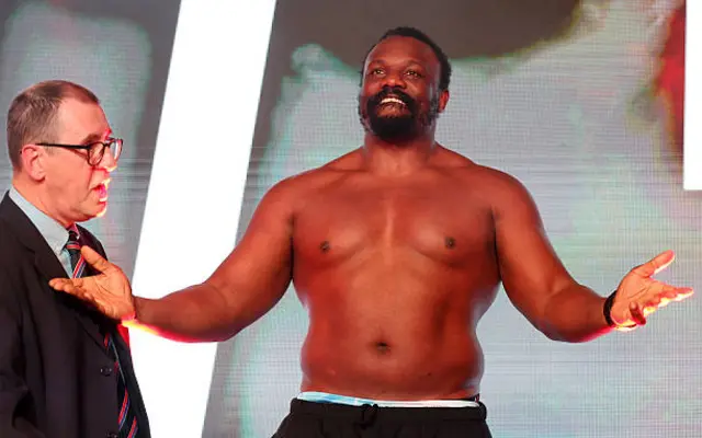 A shirtless Derek Chisora holds out his arms
