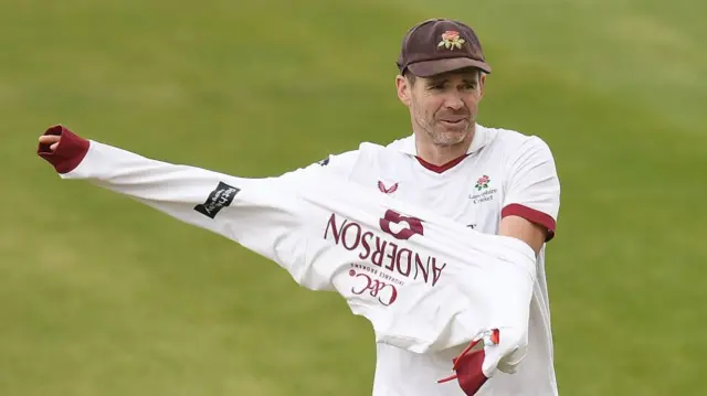 Sir Jimmy Anderson puts on his jumper