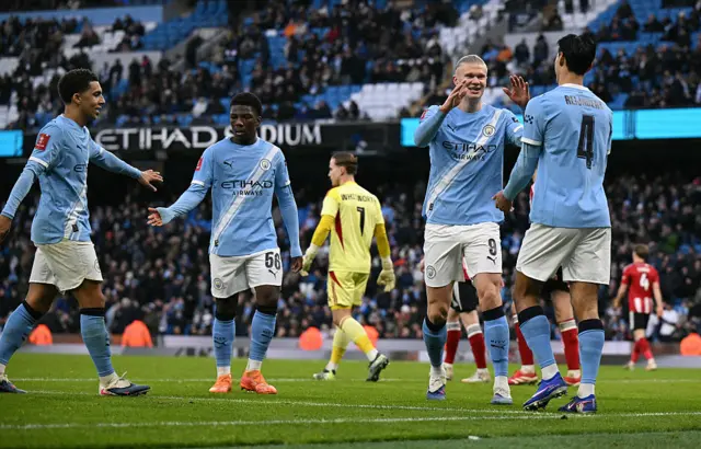 Manchester City players celebrate goal against Exeter