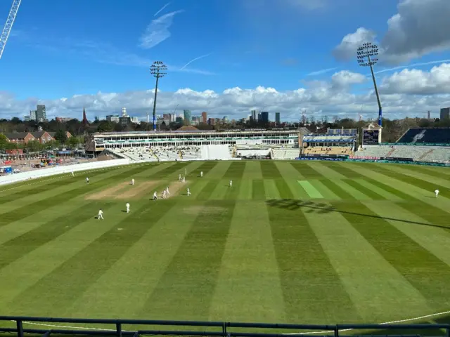 Warwickshire and Surrey cricketers playing on a sunny and blustery morning