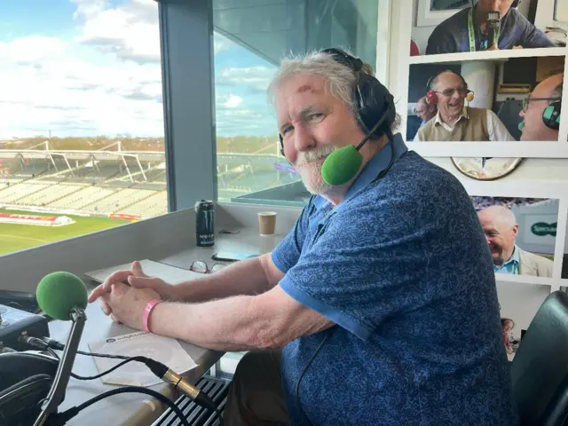 Dermot Reeve wearing his commentators headset at Edgbaston