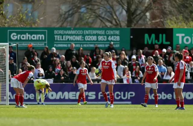 Arsenal players trudge back to kick off after conceding