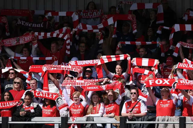 Arsenal fans hold scarves aloft