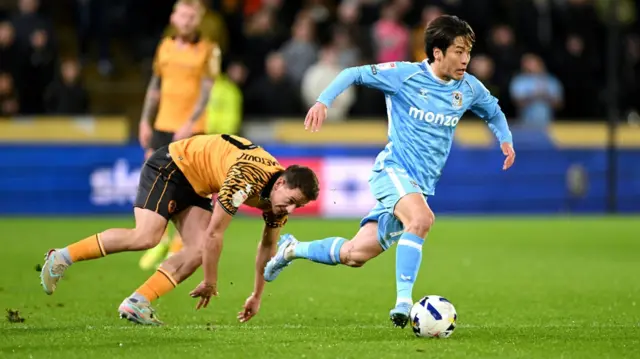 Tatsuhiro Sakamoto dribbles forward