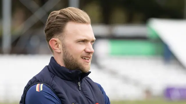 Sam Cook in Essex training gear looks on pre-match