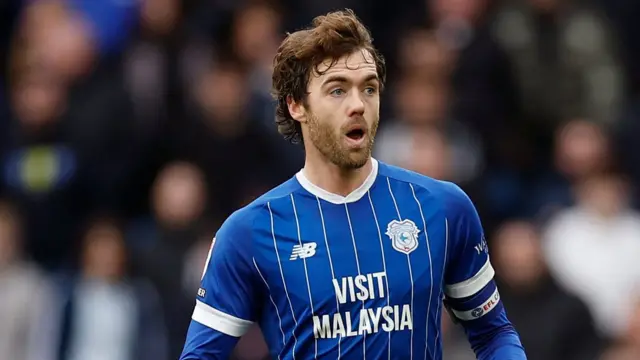 Calum Chambers, wearing the blue Cardiff home shirt and captain's armband, in action against AFC Wimbledon in February