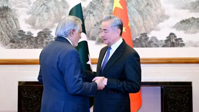 Chinese Foreign Minister Wang Yi and Pakistani Deputy Prime Minister and Foreign Minister Mohammad Ishaq Dar shake hands in Beijing