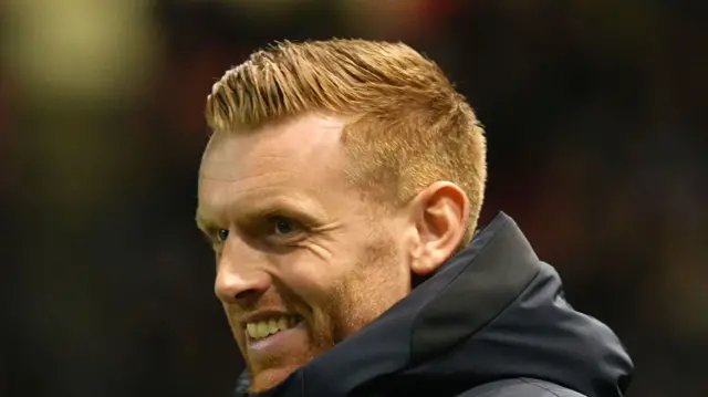 Watford head coach Ed Still smiling from the dugout.