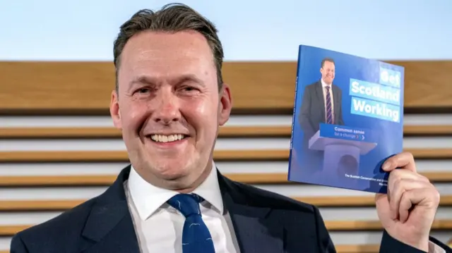 Russell Findlay holding the manifesto brochure