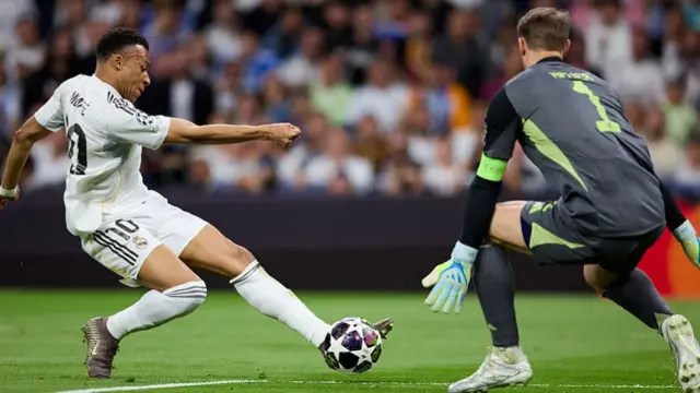 Mbappe's strike is shoved away by Manuel Neuer.