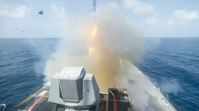 A boat firing a munition at sea