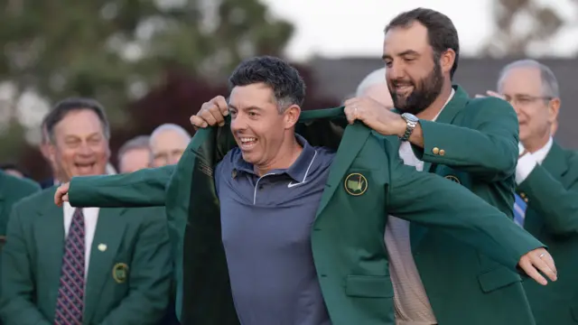 Scottie Scheffler putting the Green Jacket on Rory McIlroy in 2025
