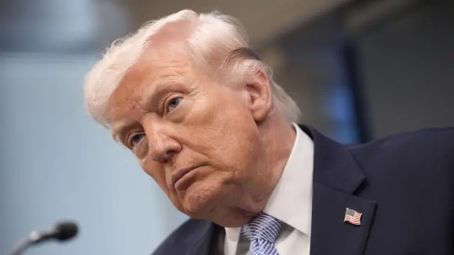 A close-up of Donald Trump's head and shoulders while standing at a lectern.