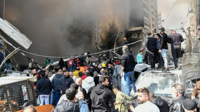 People gather at the scene of an Israeli air strike in the Corniche el-Mazraa neighbourhood of Beirut.