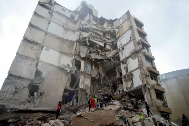 Search crews search a tower which has been struck by bombs