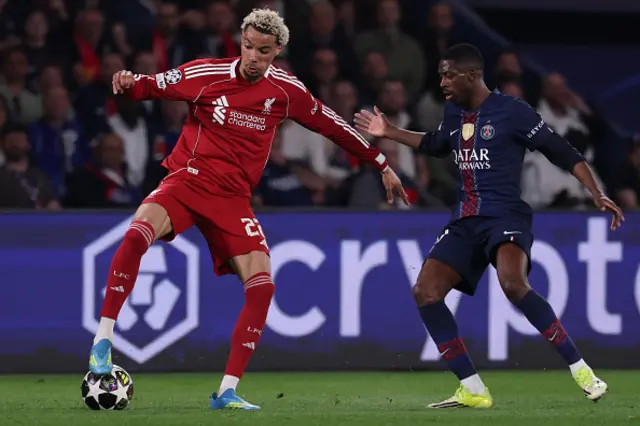 Hugo Ekitike (L) fights for the ball