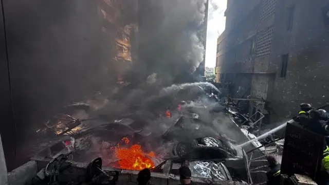 Smoke rises from burnt out cars hit in an Israeli strike on Beirut