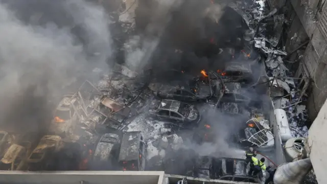 Smoke rises from burnt out cars hit in an Israeli strike on Beirut