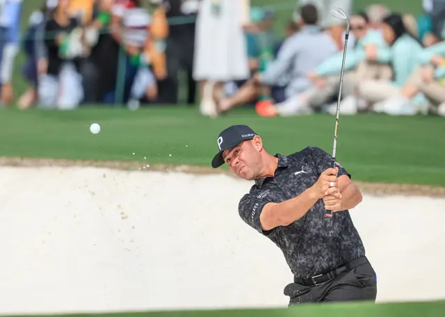 Gary Woodland splashes out of a bunker in a Masters practice round