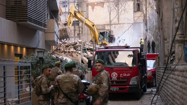 Lebanese soldiers secure the location as rescue workers search the rubble for people buried after an Israeli attack targeted residential building near the Corniche Ain Mreisse neighborhood.