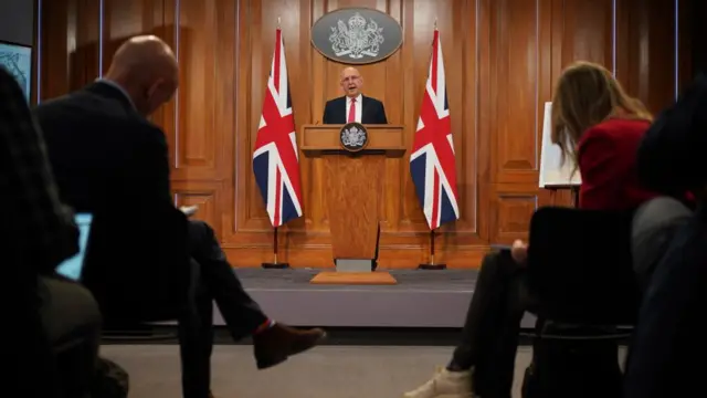 Healey delivering his speech in front of reporters in Downing Street