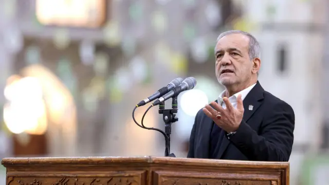 Iranian President Masoud Pezeshkian speaks into microphone