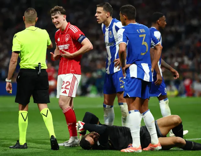 Costa holds his head on the floor as playersa argue with the ref around him