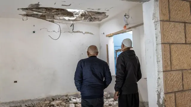 This picture, taken on 2 April, shows people in the Israeli city of Shefa-Amr inspecting damage from a rocket fired from Lebanon