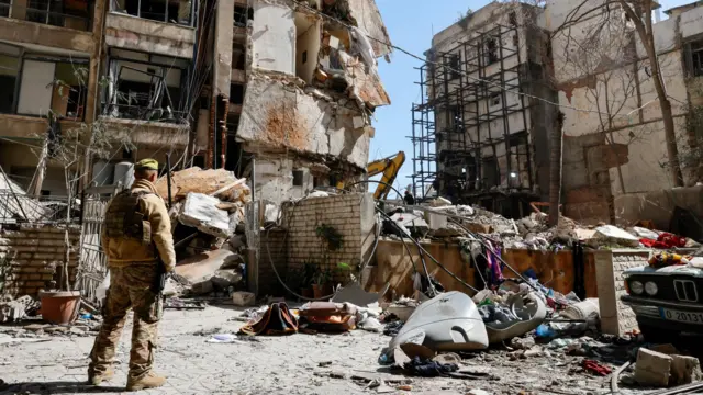 A Lebanese army soldier stands next to a destroyed residential building the day after an Israeli airstrike in the Ain Mreisseh neighborhood of Beirut, Lebanon, 09 April 2026.