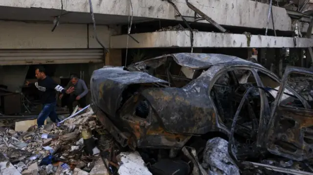 A burnt car at the site of an Israeli strike in Al-Mazraa in Beirut. The Lebanese health ministry says Israeli attacks killed at least 182 people on Wednesday