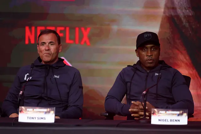Tony Sims and Nigel Benn sit beside each other at a news conference