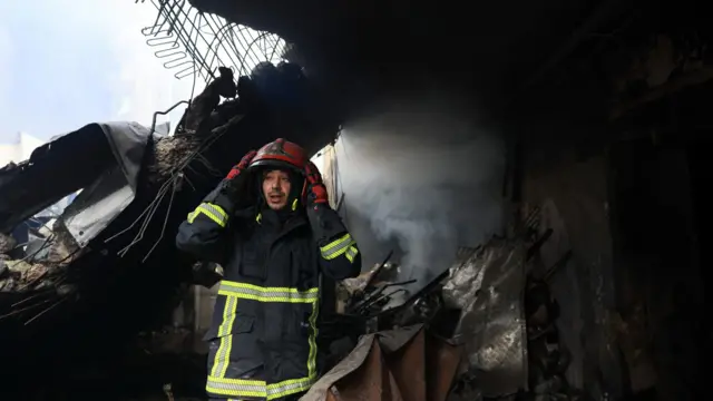 A firefighter looks on at the site of an Israeli strike carried out on Wednesday, in Al-Mazraa in Beirut